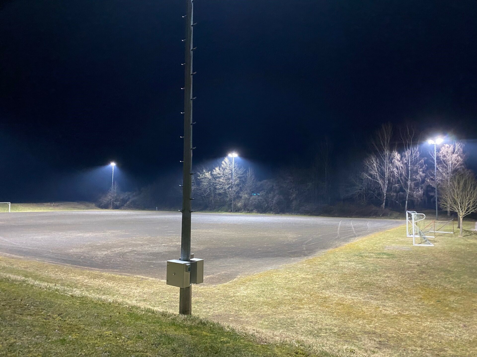 Bolzplatz bei nacht beleuchtet von Flutlichtern